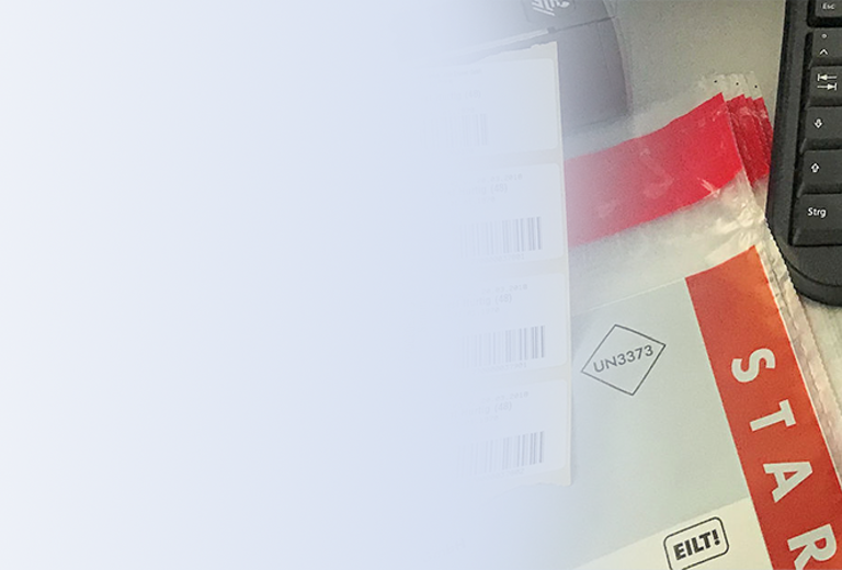 Auf einem Tisch liegen mehrere Spritzen mit bunten Kappen, ein Formular mit dem Text 'STAR' und ein schwarzes Keyboard.