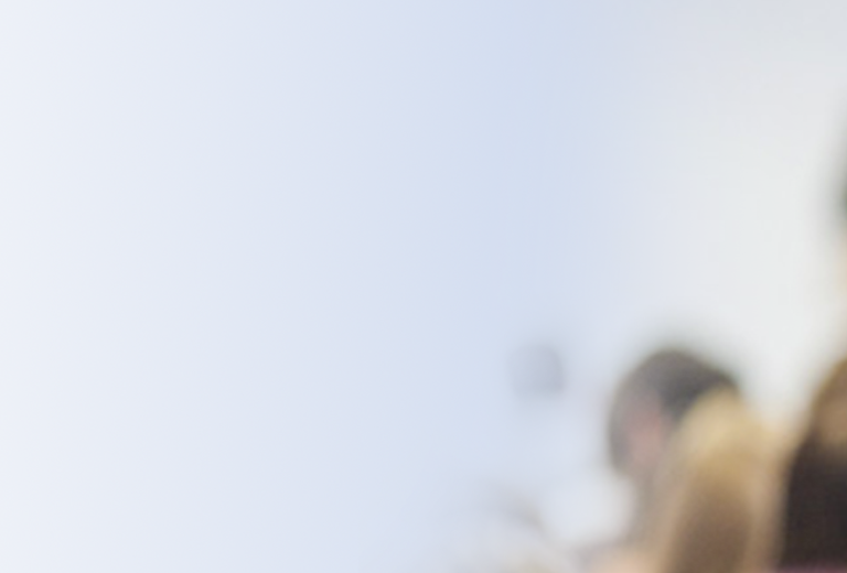 Versammlung von Personen, die einem Vortrag zuhören. Unscharfer Hintergrund mit einem Redner und einem Tisch.