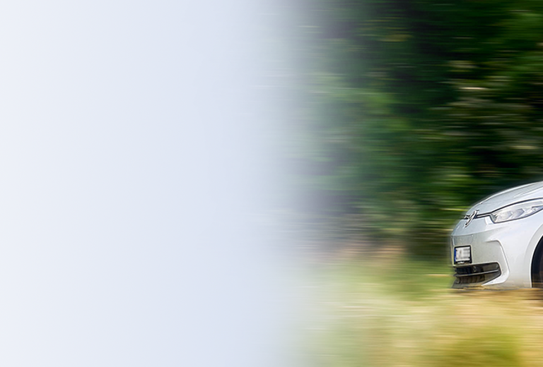 Ein weißes Auto von Medicar, der auf einer Straße fährt. Im Fahrzeug sitzt eine Fahrerin, die medizinische Laborsachen transportiert.