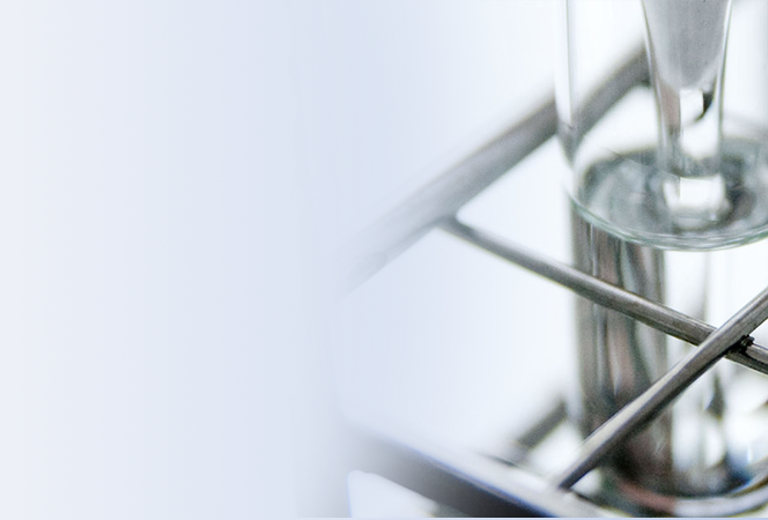 Drei gläserne Sektgläser auf einem Metallgestell, mit langen Stielen und breiten Kelchen.