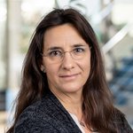 Dr. rer. nat. Sabine Gerritzen mit langen, braunen Haaren, trägt einen schwarzen Blazer und ein weißes Oberteil. 